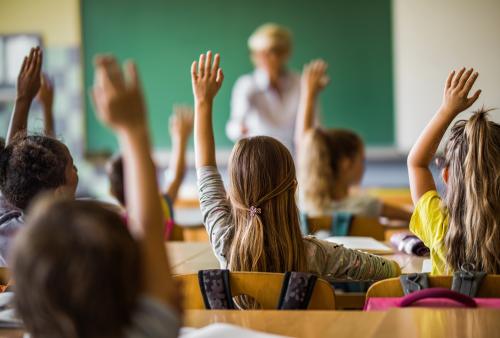 students raising hand in classroom