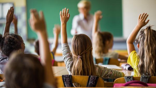 students raising hand in classroom